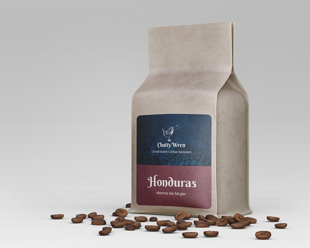 Coffee bag with red-brown label that says "Honduras: Manos de Mujer"