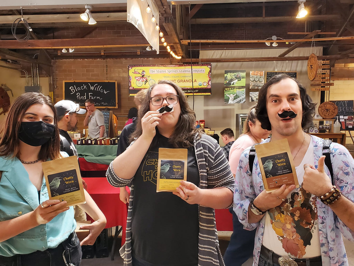 Customers posing with coffee bags and mustaches
